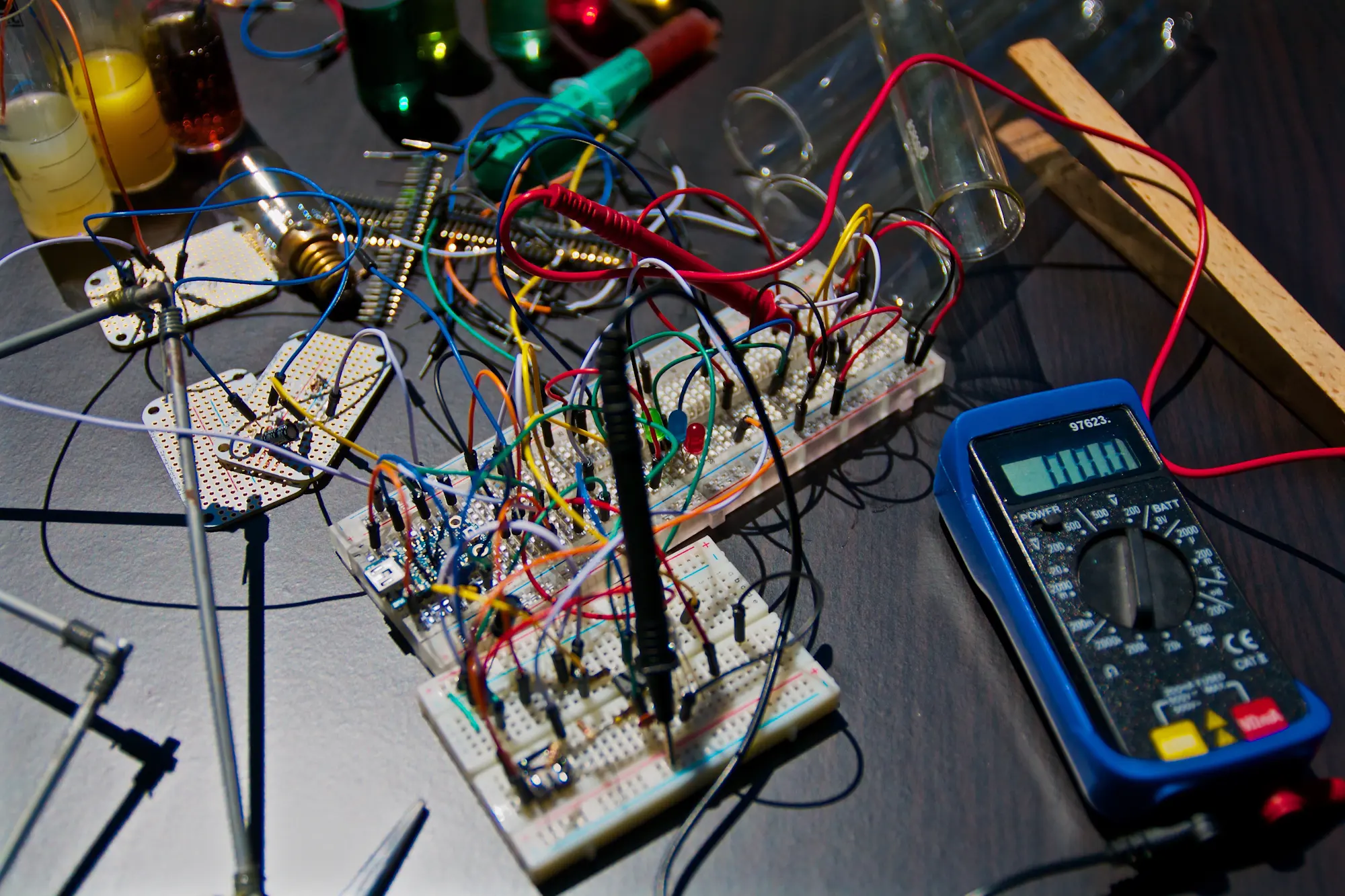 Un prototipo cableado sobre una placa de pruebas, con un polímetro midiendo