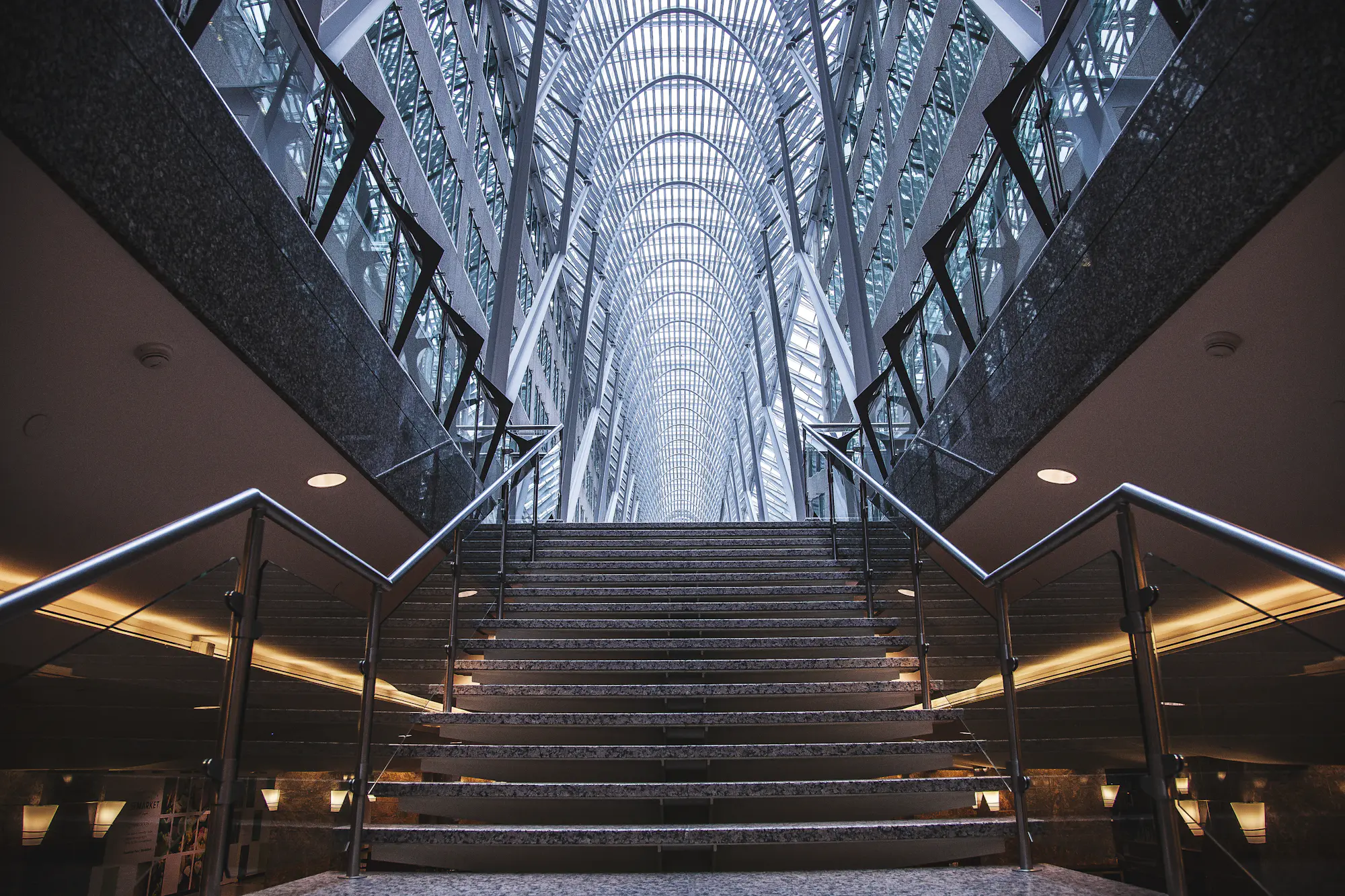 Un vestíbulo de doble altura con escalera y luz natural