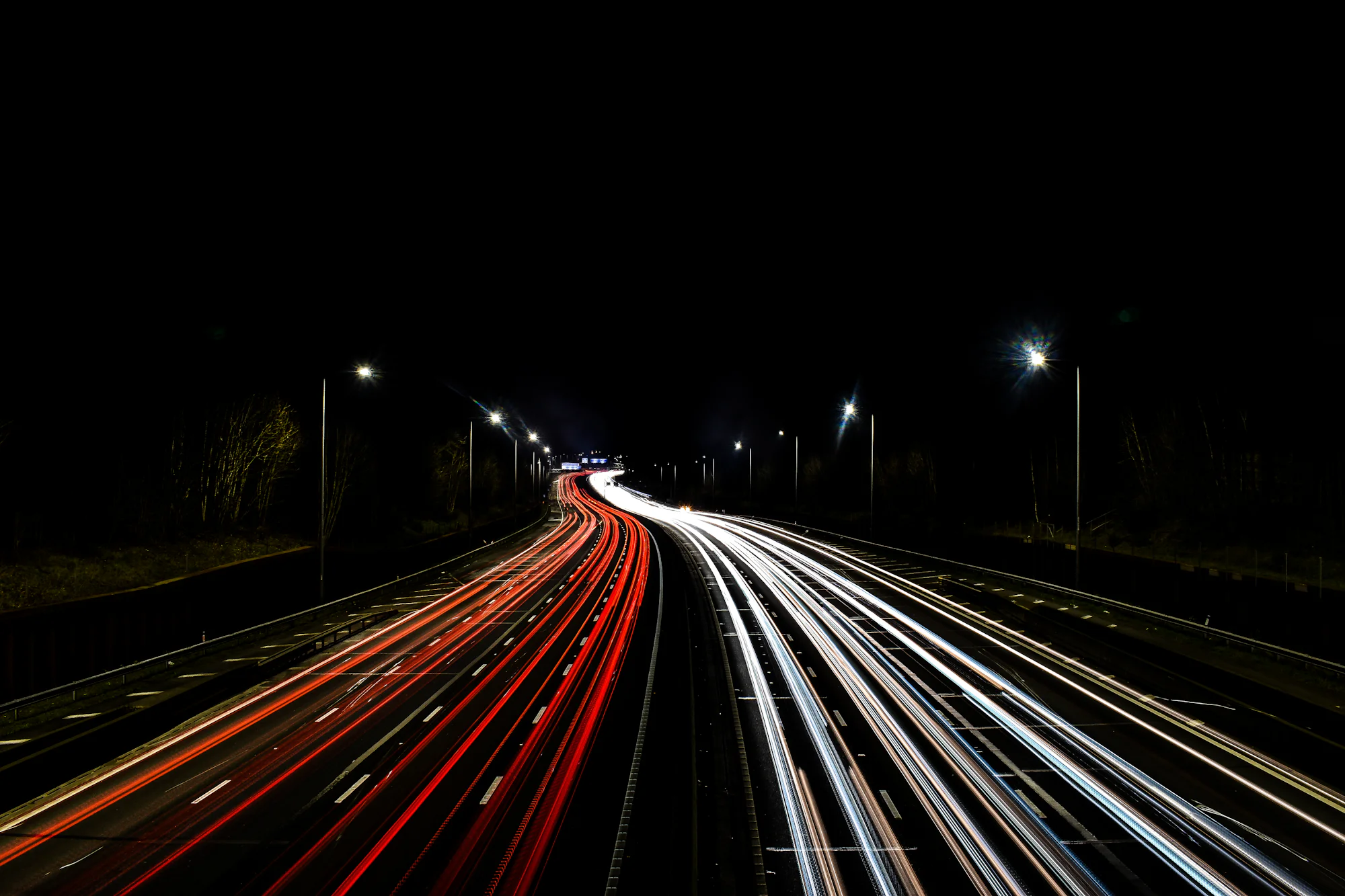 Una autopista de noche en larga exposición, con las estelas de los faros