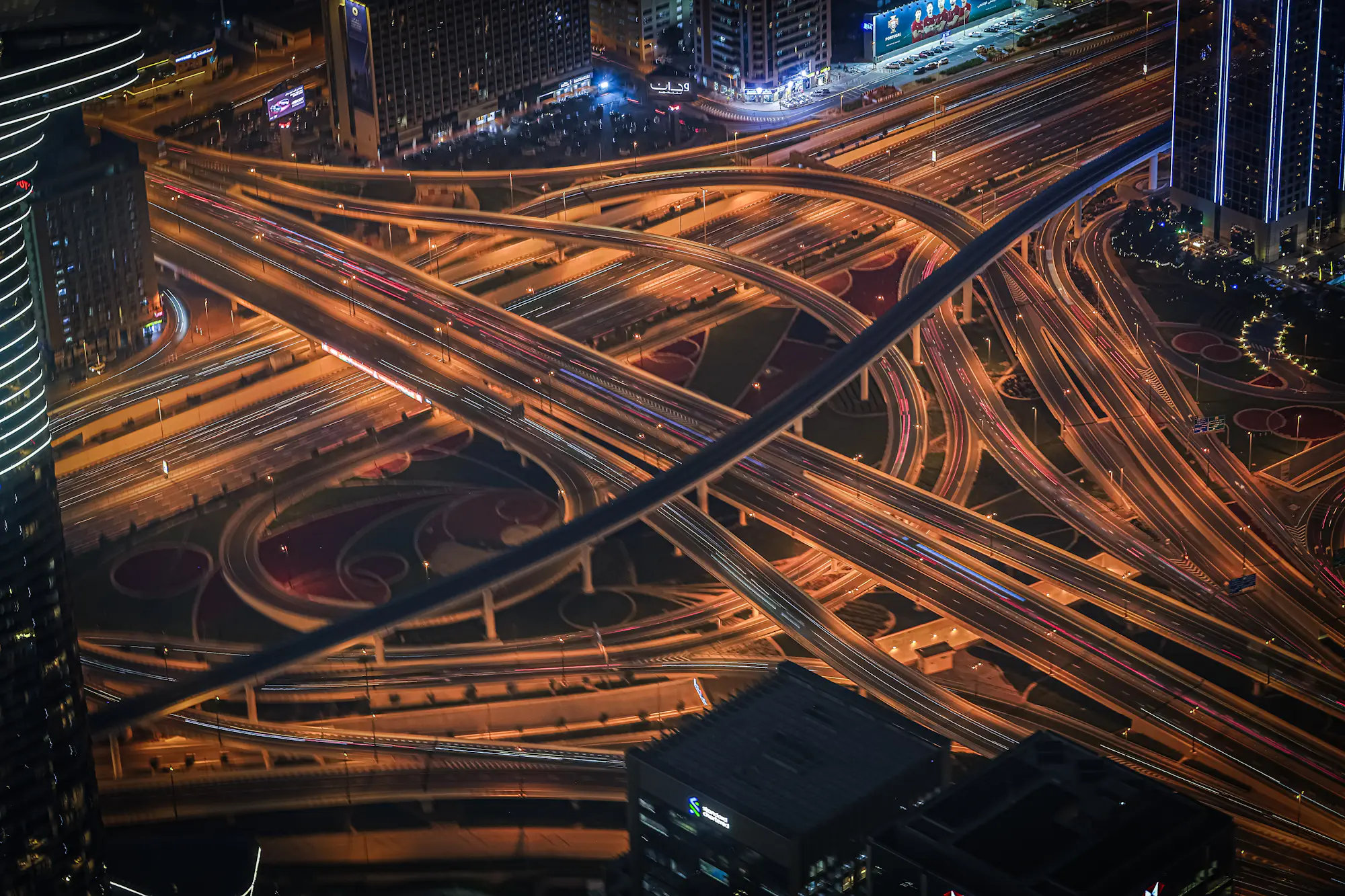 Un enlace de autopista visto desde arriba de noche, con las estelas del tráfico